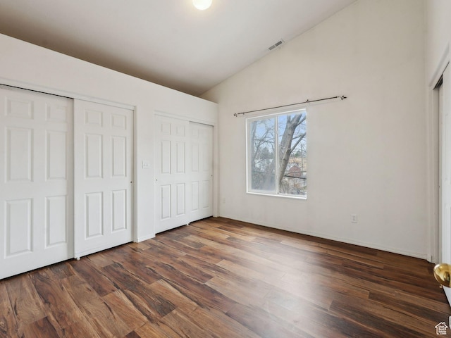 3859 S Mitchell Cv E Unit 203, South Salt Lake, UT 84115 - unfurnished bedroom with dark hardwood / wood-style floors, vaulted ceiling, and two closets