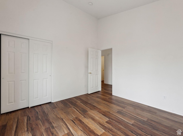 3859 S Mitchell Cv E Unit 203, South Salt Lake, UT 84115 - unfurnished bedroom with dark wood-type flooring, a high ceiling, and a closet