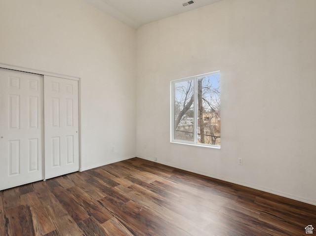 3859 S Mitchell Cv E Unit 203, South Salt Lake, UT 84115 - unfurnished bedroom with dark wood-type flooring, a high ceiling, and a closet
