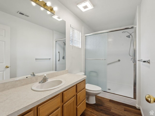 3859 S Mitchell Cv E Unit 203, South Salt Lake, UT 84115 - bathroom featuring vanity, wood-type flooring, a shower with shower door, and toilet