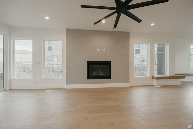 994 W Union Bench Dr S, Mapleton, UT 84664 - unfurnished living room featuring light wood-type flooring, recessed lighting, baseboards, and a glass covered fireplace