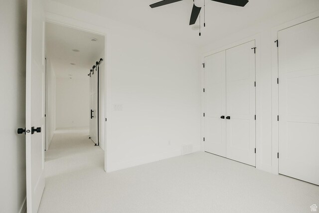 994 W Union Bench Dr S, Mapleton, UT 84664 - unfurnished bedroom featuring carpet floors, a barn door, ceiling fan, and a closet