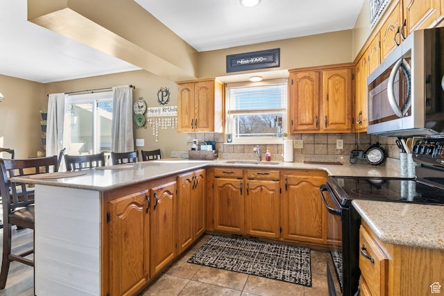 440 W Cottonwood Ln, Ferron, UT 84523 - kitchen with a breakfast bar, sink, kitchen peninsula, black range with electric stovetop, and decorative backsplash
