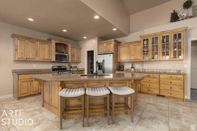 1679 N 4400 W, Plain City, UT 84404 - kitchen with a breakfast bar, sink, a kitchen island with sink, light tile patterned floors, and stainless steel appliances