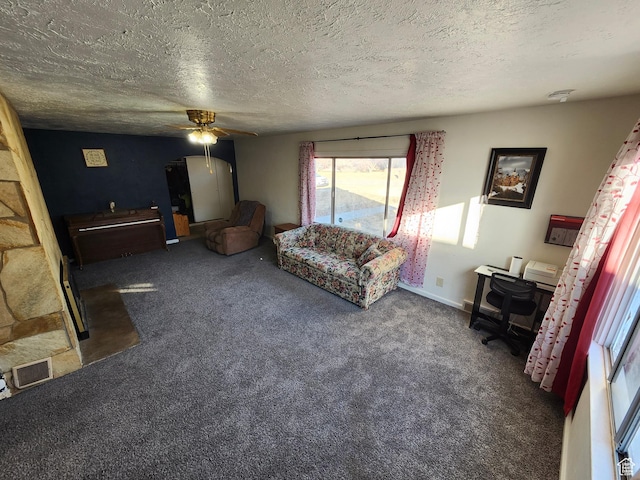 carpeted living room featuring ceiling fan and a textured ceiling