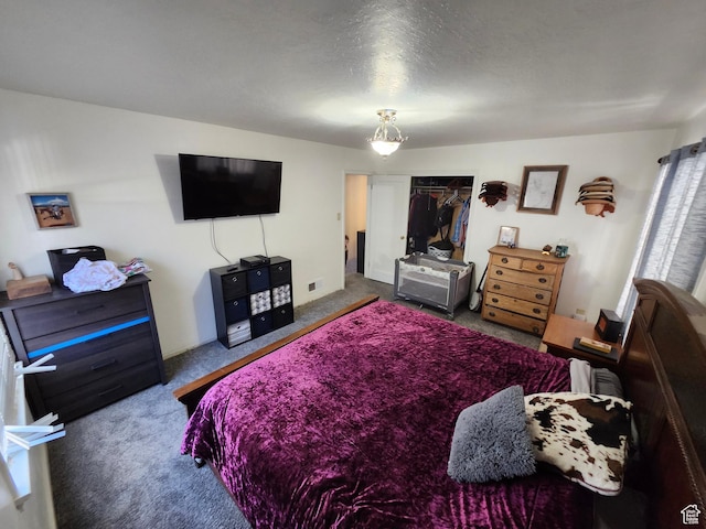 carpeted bedroom featuring a textured ceiling and a closet