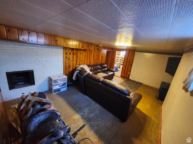 living room with a brick fireplace and wooden walls