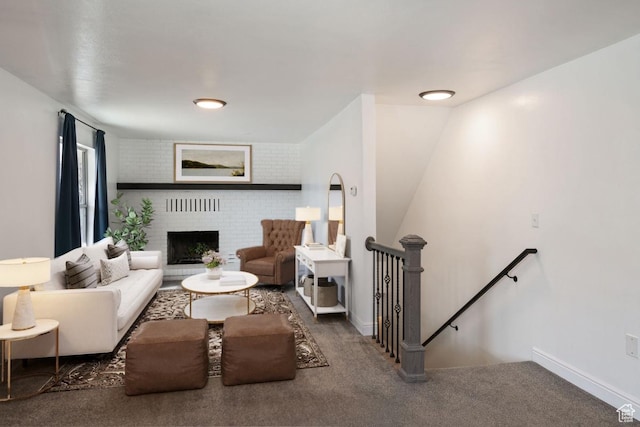 carpeted living area featuring a fireplace and baseboards