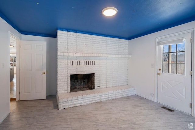 unfurnished living room with visible vents, baseboards, and a fireplace