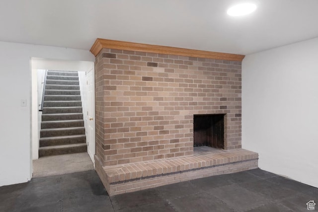 unfurnished living room featuring stairs, a fireplace, and concrete floors