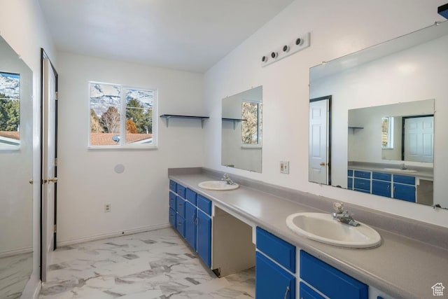 bathroom with double vanity, marble finish floor, and a sink