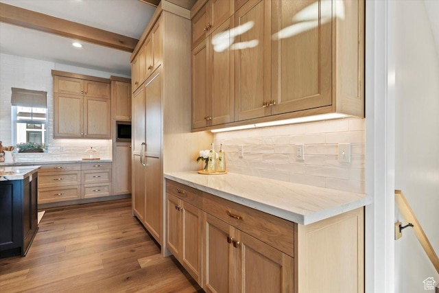 kitchen featuring built in microwave, beamed ceiling, light hardwood / wood-style floors, and light brown cabinets