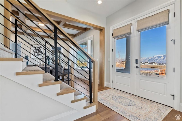 entrance foyer with wood-type flooring, a mountain view, and french doors