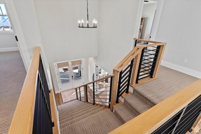 stairs featuring a chandelier and carpet floors