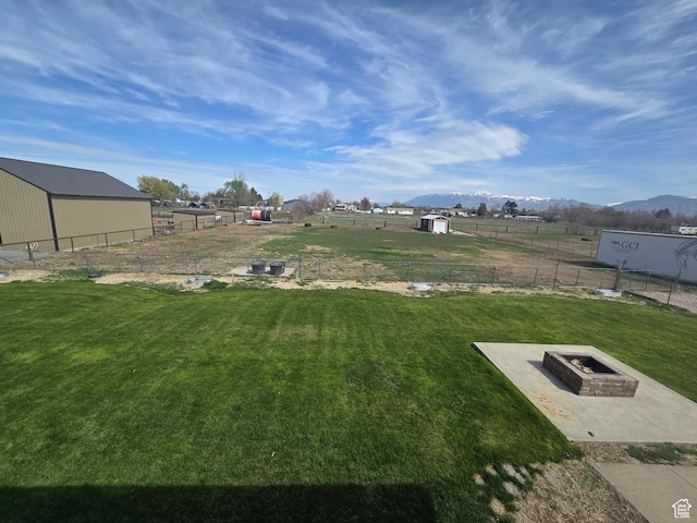 4556 W 4950 S, Hooper, UT 84315 - view of yard featuring a mountain view, a fire pit, a storage shed, an outbuilding, and fence