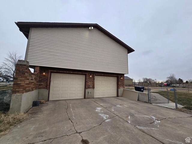 4556 W 4950 S, Hooper, UT 84315 - view of property exterior with brick siding, driveway, fence, and a garage