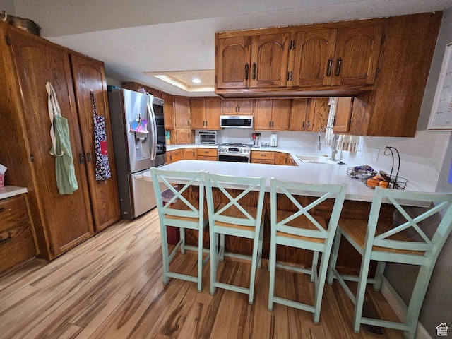4556 W 4950 S, Hooper, UT 84315 - kitchen featuring light wood-style floors, a peninsula, light countertops, a sink, and stainless steel appliances