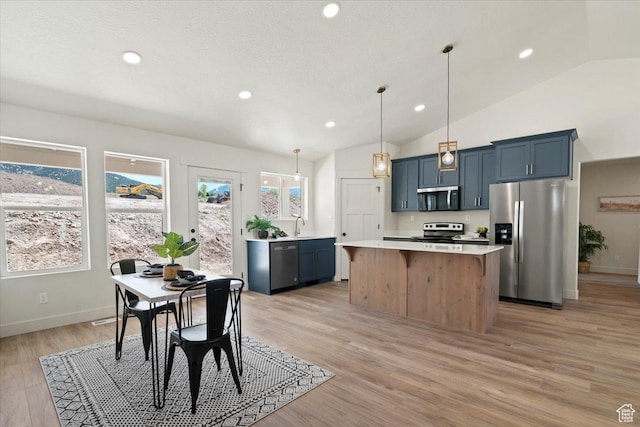 kitchen featuring lofted ceiling, stainless steel appliances, recessed lighting, a center island, and light countertops