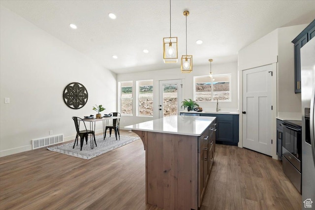 kitchen with visible vents, electric range oven, dark wood-style floors, and a sink