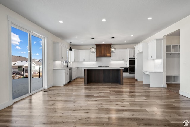 1002 W Temple Rim Ln, Payson, UT 84651 - kitchen featuring a kitchen island, decorative light fixtures, white cabinets, stainless steel appliances, and light wood-type flooring