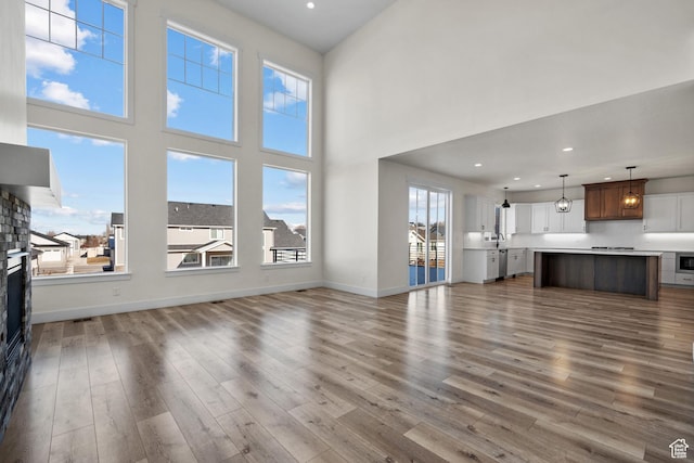 1002 W Temple Rim Ln, Payson, UT 84651 - unfurnished living room featuring wood-type flooring, a towering ceiling, and sink