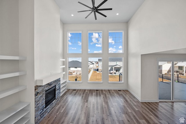 1002 W Temple Rim Ln, Payson, UT 84651 - unfurnished living room with a towering ceiling, a fireplace, hardwood / wood-style flooring, ceiling fan, and built in shelves