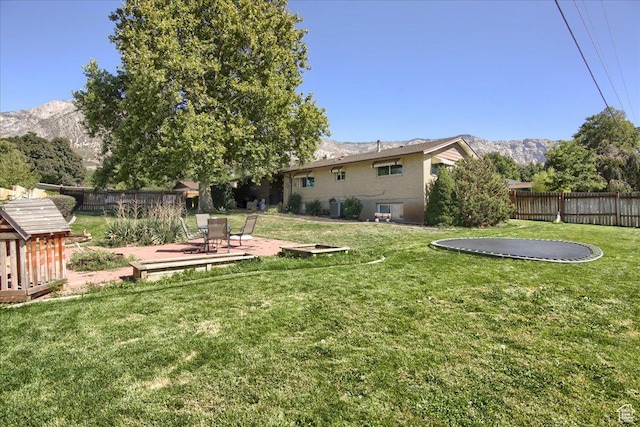 3095 N 275 E, North Ogden, UT 84414 - view of yard featuring a patio, a trampoline, a fenced backyard, and a mountain view