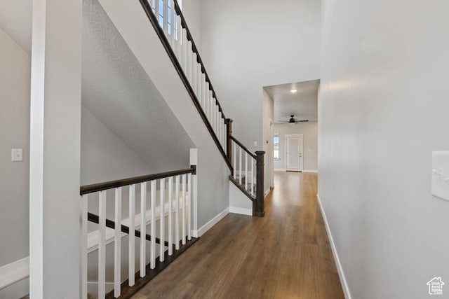 hallway with stairway, baseboards, and wood finished floors
