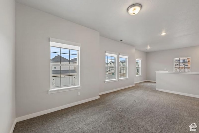 carpeted empty room with baseboards