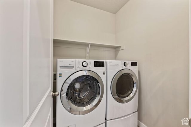 clothes washing area with separate washer and dryer, laundry area, and baseboards