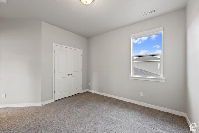 carpeted empty room featuring baseboards and visible vents