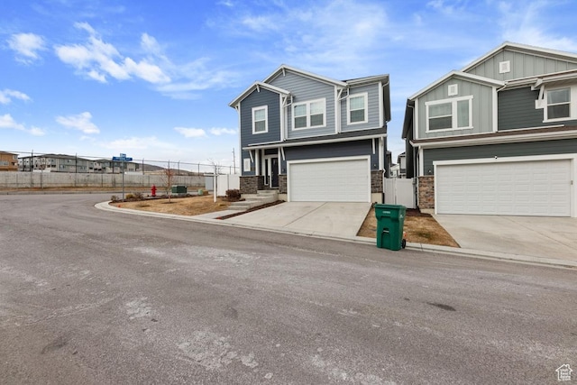 view of front facade featuring an attached garage, fence, and driveway