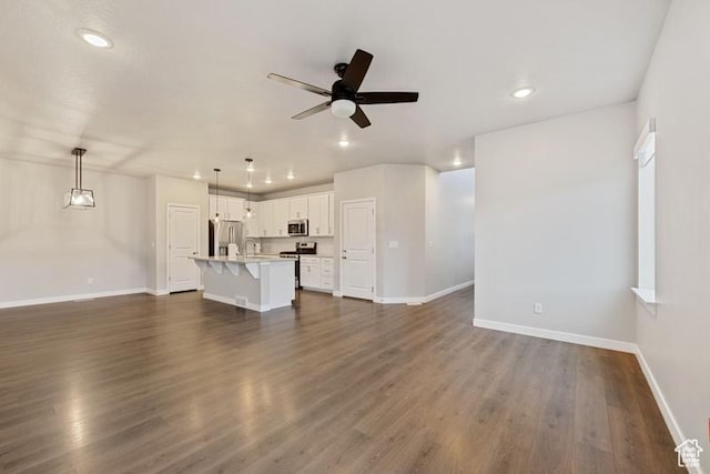 unfurnished living room with recessed lighting, dark wood-style flooring, baseboards, and a ceiling fan