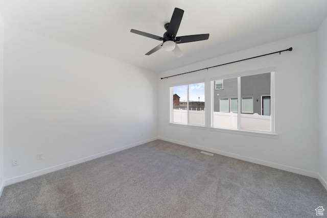 carpeted empty room with baseboards and ceiling fan