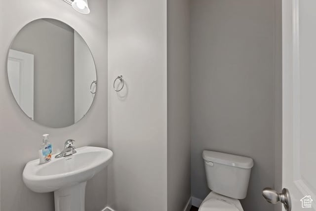 half bath with toilet and baseboards