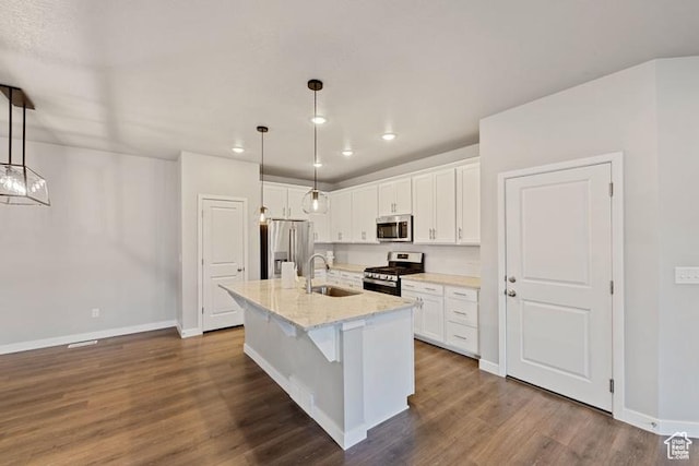 kitchen with baseboards, a sink, white cabinetry, and appliances with stainless steel finishes