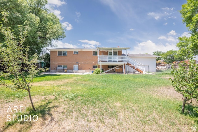 rear view of property featuring a wooden deck and a lawn
