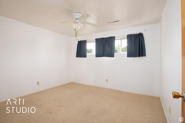 carpeted spare room with ceiling fan