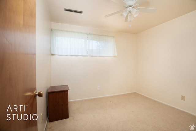 unfurnished room with light colored carpet and ceiling fan