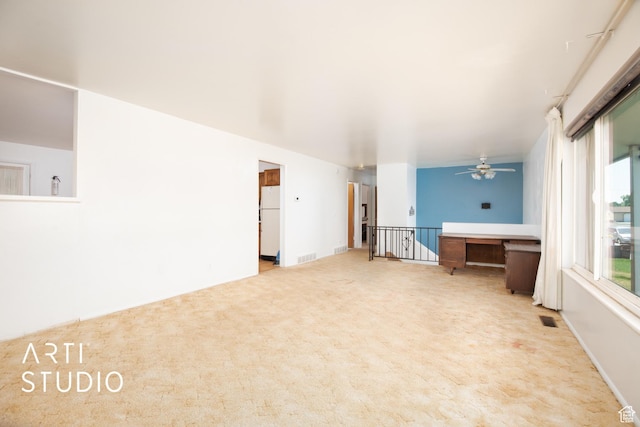 carpeted spare room with ceiling fan