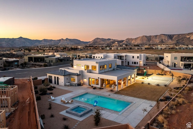 4862 N Sand Cove Cir, St George, UT 84770 - back house at dusk with an in ground hot tub, a mountain view, and a patio area