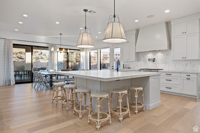 4862 N Sand Cove Cir, St George, UT 84770 - kitchen with decorative light fixtures, custom range hood, and a large island with sink
