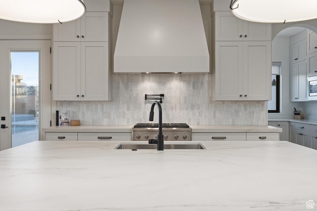 4862 N Sand Cove Cir, St George, UT 84770 - kitchen featuring white cabinetry, premium range hood, backsplash, and light stone counters