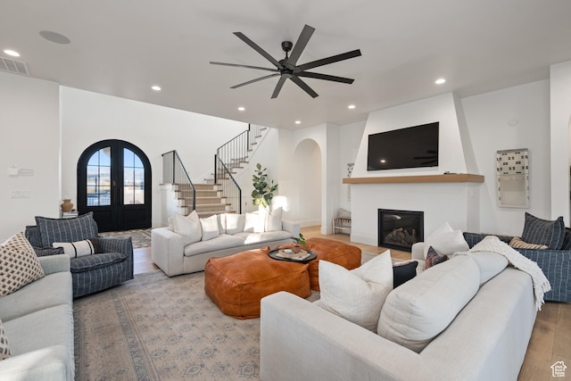 4862 N Sand Cove Cir, St George, UT 84770 - living room featuring a fireplace, light hardwood / wood-style floors, french doors, and ceiling fan