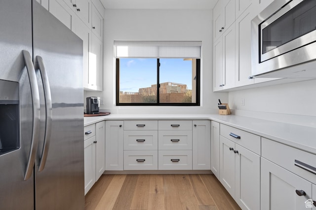 4862 N Sand Cove Cir, St George, UT 84770 - kitchen with appliances with stainless steel finishes, white cabinets, and light hardwood / wood-style flooring