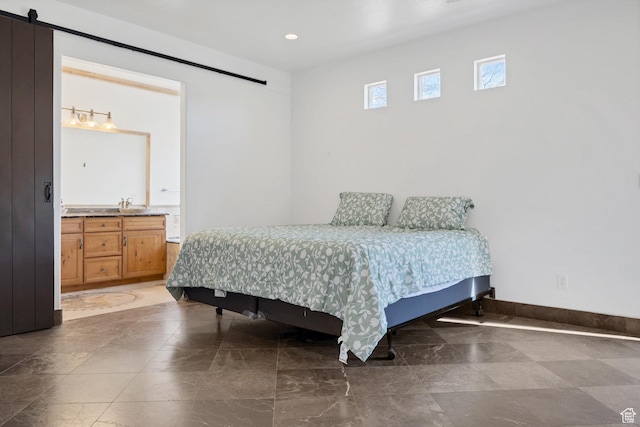 2261 S Tonaquint Dr Unit 8, St George, UT 84770 - bedroom featuring a barn door, sink, and connected bathroom