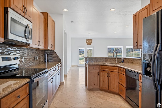 2261 S Tonaquint Dr Unit 8, St George, UT 84770 - kitchen with sink, hanging light fixtures, light stone countertops, decorative backsplash, and black appliances