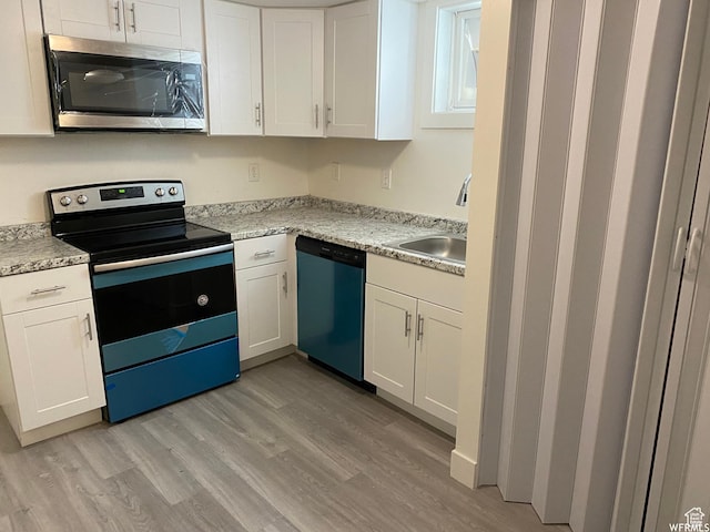 230 N 3rd St, Tooele, UT 84074 - kitchen with stainless steel appliances, white cabinetry, sink, and light wood-type flooring