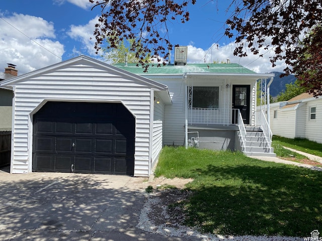 230 N 3rd St, Tooele, UT 84074 - view of front of property featuring a porch, a garage, an outdoor structure, and a front lawn
