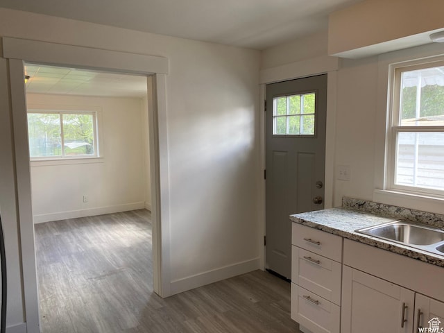 230 N 3rd St, Tooele, UT 84074 - kitchen with light stone counters, plenty of natural light, light wood-type flooring, and white cabinets